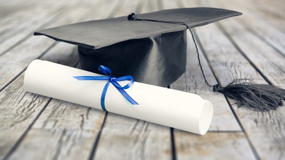Un diplôme est posé sur le sol à côté d'un chapeau.